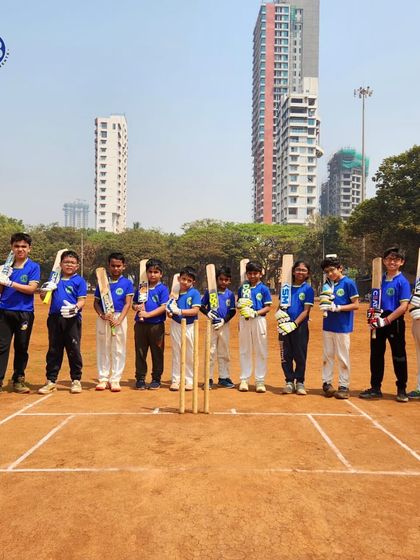 A young cricket team lined up on the pitch, ready for their match. This image shows the discipline and readiness we instill in our athletes before a game.