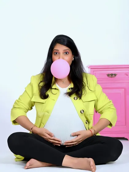 A quirky and fun maternity portrait with the mom-to-be blowing a bubblegum bubble.