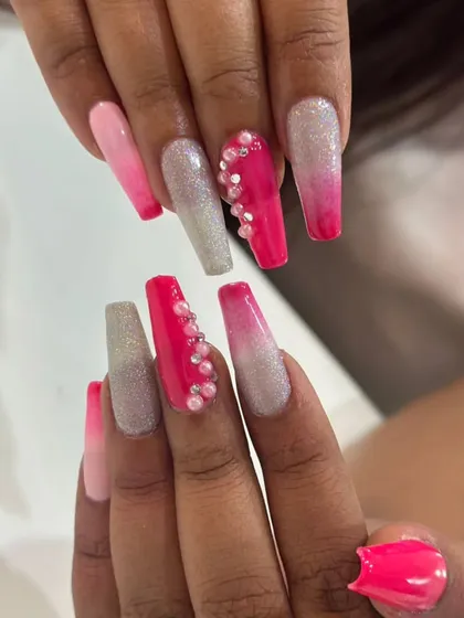 A vibrant pink ombre set on long coffin nails, featuring silver glitter and pearl accents for a bold, Barbie-inspired look.