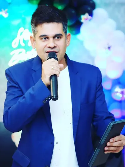 A classic host pose, mic in hand, ready to command the stage. The blue blazer adds a pop of color and professionalism.