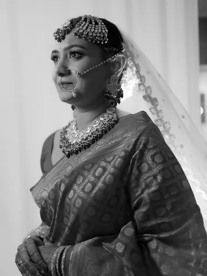 A classic black and white bridal portrait, her expression poised and elegant, showcasing her traditional Maharashtrian jewelry.