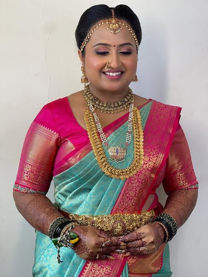 This close-up highlights the flawless base and soft eye makeup that define Supritha's Muhurtham look. The traditional matha patti and nose ring are key elements of her bridal styling.