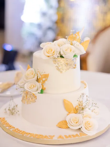 A cake fit for a queen! This stunning two-tier white and gold cake, decorated with delicate sugar flowers and gold leaf, was the sweet centerpiece of this milestone birthday party.
