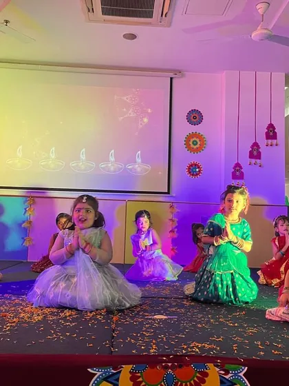 Little girls in colorful lehengas perform a graceful dance on stage, their smiles lighting up the Dussehra celebration.
