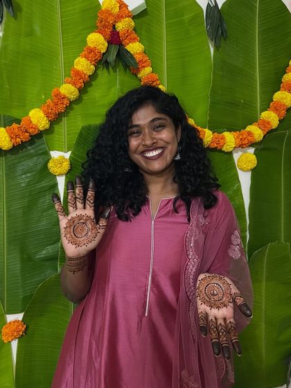 A happy minimal bride showing off her beautiful mandala mehendi. Her smile says it all.