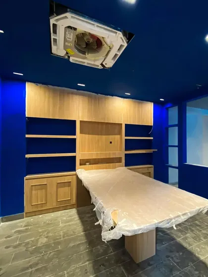 The vibrant royal blue paint being applied to the walls and ceiling, a signature element of the Weatherseal brand identity. This image captures the moment the space begins to reflect the bold design concept.