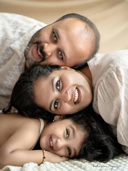 A fun, stacked family portrait, with everyone's smiling faces lined up. A creative and joyful shot.