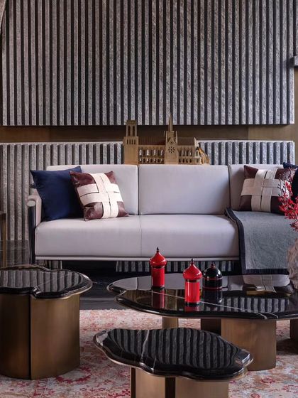 The living room's backdrop features a stone finish with elegant vertical slats, evoking a sense of calm. The design proves that raw materials, when used thoughtfully, can create an atmosphere of serene luxury.