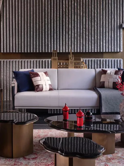 The living room's backdrop features a stone finish with elegant vertical slats, evoking a sense of calm. The design proves that raw materials, when used thoughtfully, can create an atmosphere of serene luxury.