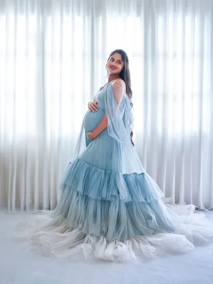 The Winter gown, with its layers of blue and white tulle, creates a beautiful ombre effect. It's a perfect choice for a serene and elegant photoshoot.