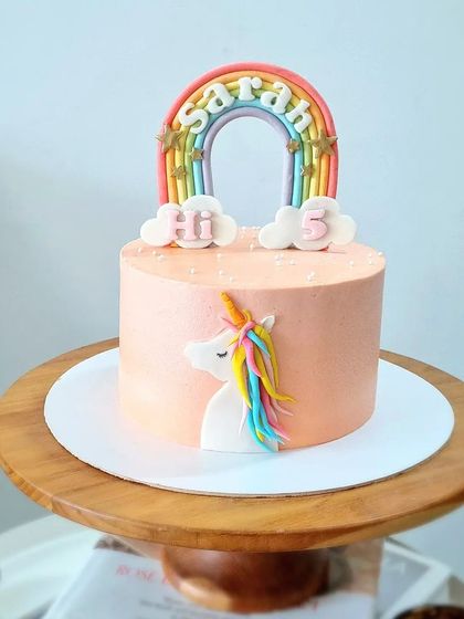 A simple and sweet unicorn cake with a pastel rainbow topper.