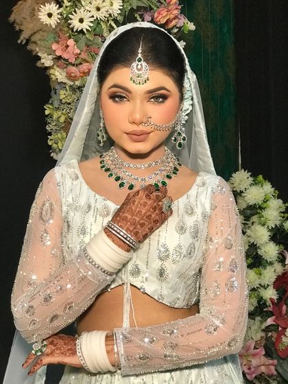 Another portrait of the bride in the white lehenga, showing her elegant makeup and hairstyle.