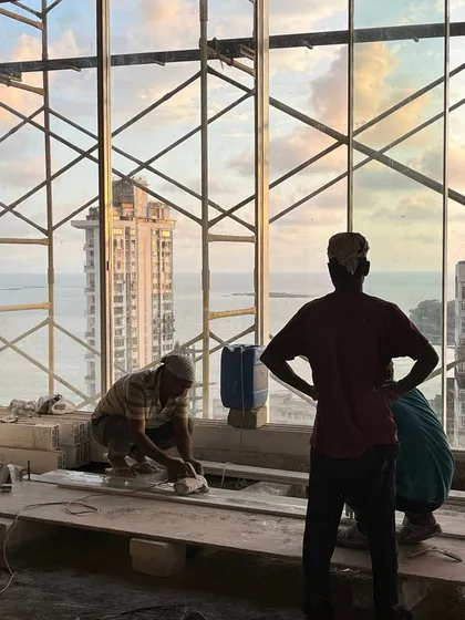The human element is central to construction. Here, workers are on-site at our Walkeshwar project, their forms silhouetted against the sunset over the Mumbai skyline. It is a reminder of the collaborative effort required to bring a vision to life.