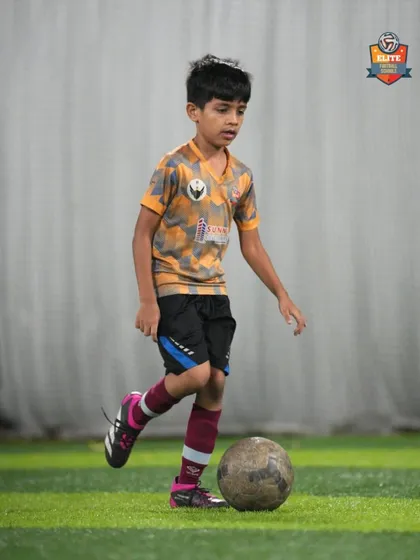 A young player practices his passing technique, focusing on accuracy and proper form.