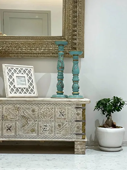 Detail is key in creating an authentic aesthetic. Here, distressed turquoise candle holders and a hand-carved chest add color, texture, and a sense of history to the space.