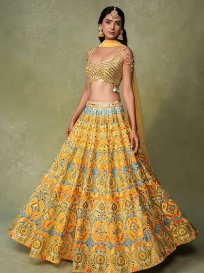 A classic e-commerce photo of a beautifully printed lehenga. The model is posed to show the full volume of the skirt and the details of the matching blouse.