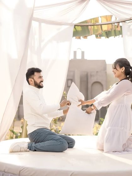 A fun and energetic pillow fight in a beautiful white tented set. I love capturing these playful moments that show the joyful side of your relationship.