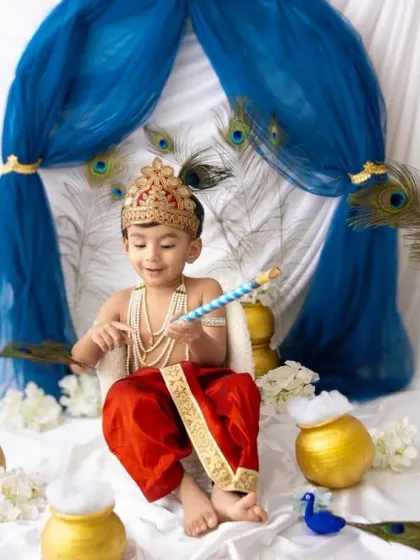 Playing with his flute and a peacock feather. These are the candid, playful moments that truly capture the spirit of little Krishna.