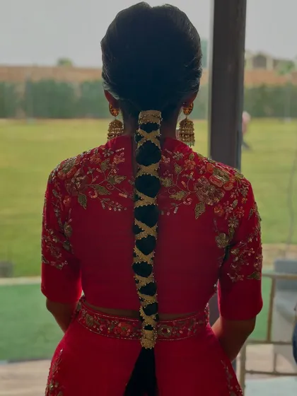 A close-up of a Mehndi braid, this time adorned with a golden ribbon crisscrossing down its length. This is a great way to match the hair to a golden-threaded outfit.