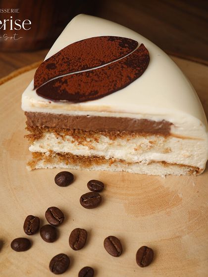 Satisfy your coffee cravings with every bite of my Tiramisu. This slice shows the beautiful layers and coffee bean garnish.