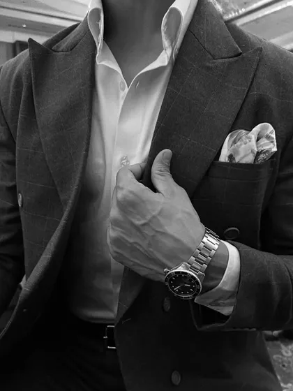 The difference is in the details. This close-up of a custom double-breasted suit highlights the sharp peak lapel, the perfect pocket square, and the way the fabric drapes. We believe true elegance is achieved through meticulous attention to every single element.