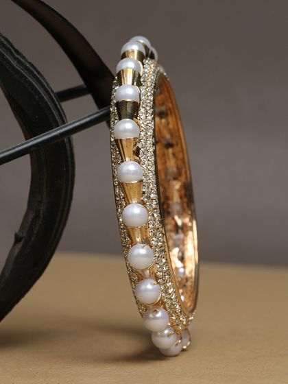 A beautiful pearl and stone-studded kada bangle.