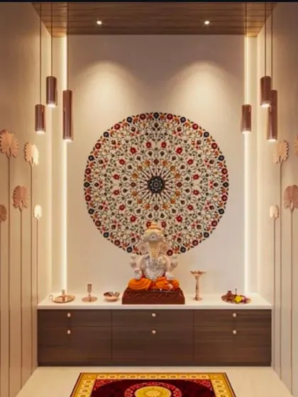 A vibrant and modern take on a pooja corner, this design features a colorful mosaic mandala as the centerpiece. Sleek, cylindrical pendant lights and subtle lotus-shaped wall accents create a sophisticated and artistic ambiance around the Ganesha idol.