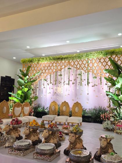 A beautiful stage with a gold lattice backdrop, flanked by large banana plants for a natural, earthy feel.