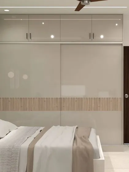 This sliding wardrobe combines smooth, high-gloss laminate doors with a central band of fluted wood paneling. This two-tone, multi-texture approach adds visual interest and warmth to the bedroom while providing efficient, space-saving storage.