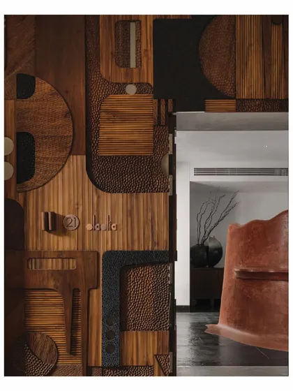 The main door of the Aria home is a story in itself, a complex collage of reclaimed wood, hammered leather, and fluted textures. It serves as a prelude to the narrative within, where every surface is considered and every detail is crafted with intention.