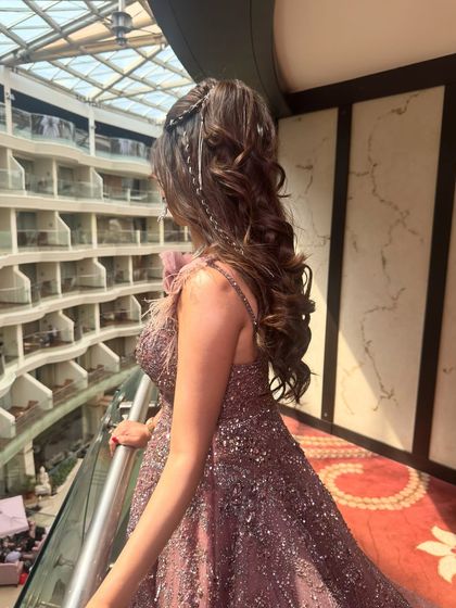 This shot captures the texture and volume of the curls from the side. The half up style provides structure, while the loose curls feel soft and romantic.