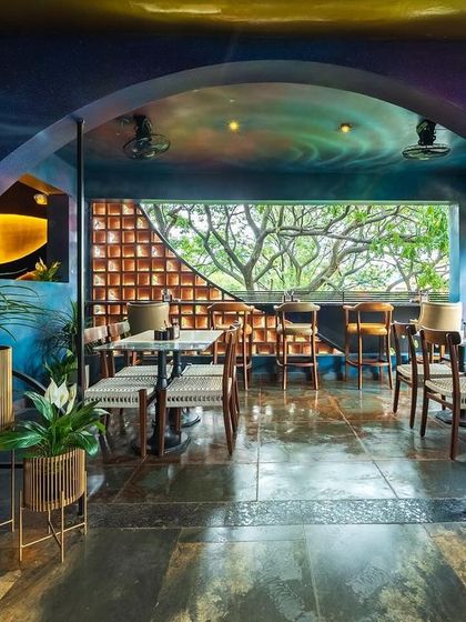 The finished dining space, where a cosmic mural and terracotta jali wall come together. This project showcases our ability to completely transform a space with color, art, and architectural details.