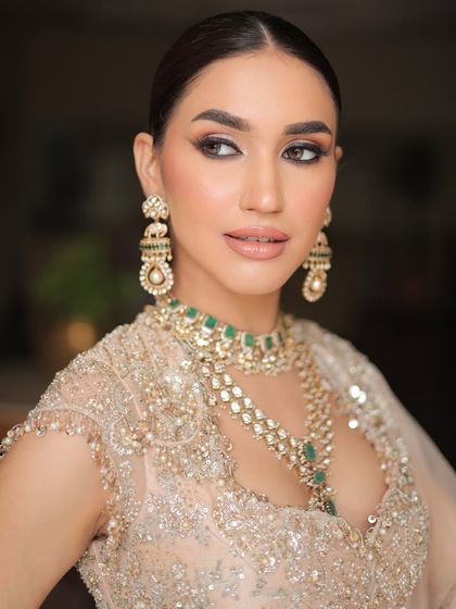 A close-up on the intricate details of a minimal yet powerful bridal look. The focus is on the bride's confident gaze and the subtle sparkle of her jewelry.