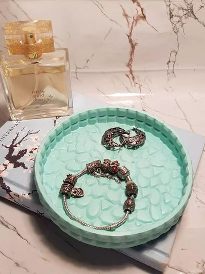 Our round marshmallow tray in a lovely mint green. The textured surface adds a unique detail, making it a stylish spot for your jewelry.