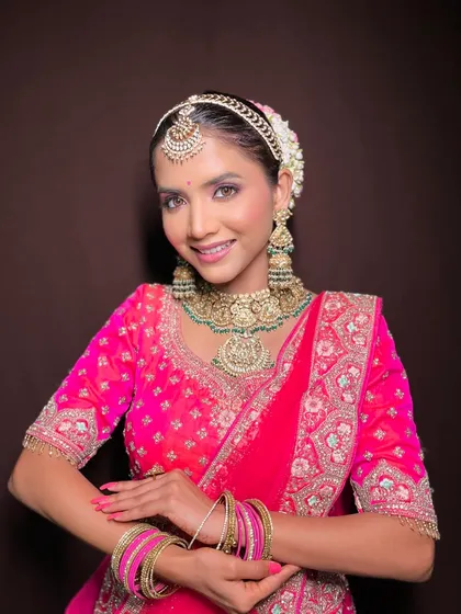 A front-facing portrait of the model in her stunning pink bridal attire.