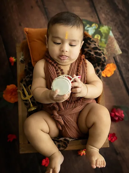 A moment of quiet curiosity as the baby inspects his damaru.
