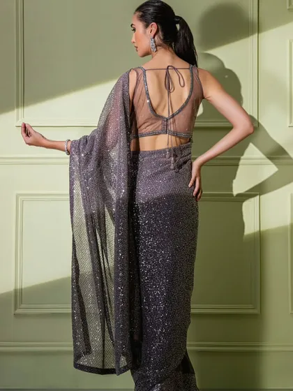 The sheer, alluring back of the grey ombre sequin saree's blouse.