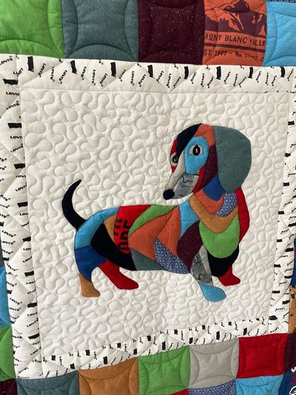 A close-up of the custom dachshund appliqué from the T-shirt memory quilt, surrounded by stippling stitches.