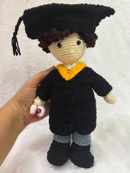 Holding the graduation doll to show its size. It stands about 8-10 inches tall.