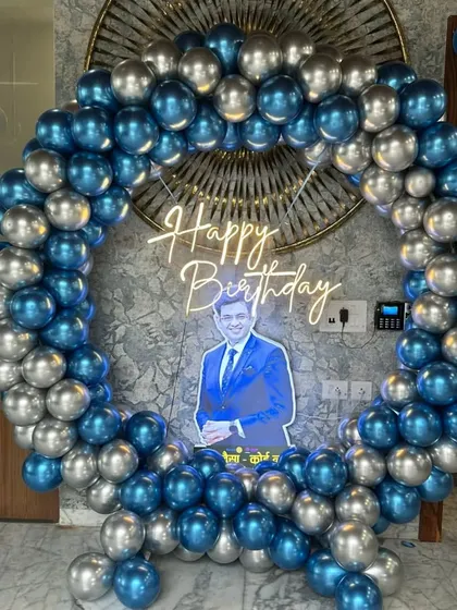 A personalized balloon ring in metallic blue and silver. I included a custom cutout photo of the birthday person inside the ring, making it a truly unique and special decoration.