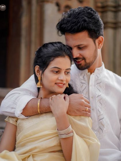 A close-up, intimate portrait from the same temple shoot. The focus is on their gentle embrace and the beautiful details of their attire.