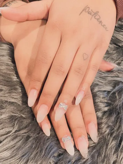 A subtle and elegant choice for a bride. These are natural-looking translucent extensions with delicate silver glitter bow accents.