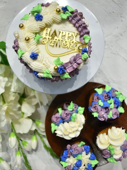 Another beautiful Raksha Bandhan set, this time with a cake and cupcakes decorated with purple and blue floral piping and gold accents.