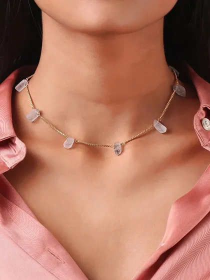 A tight shot of a choker-style necklace, emphasizing the texture of the stones and the fine chain.
