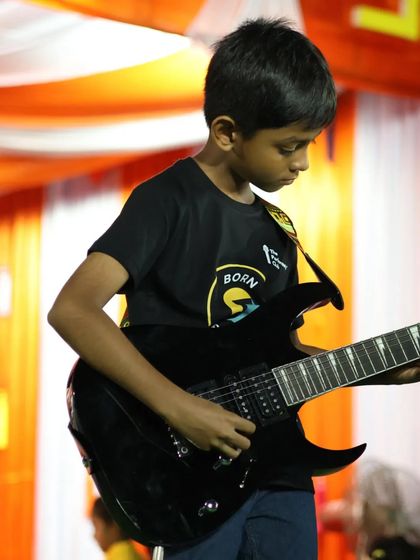 Close-up of one of our young electric guitarists, showing intense concentration during his performance. The future of rock is here!