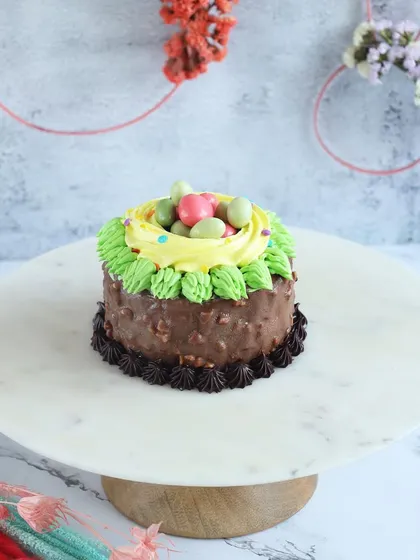 A nutty chocolate Easter cake decorated to look like a bird's nest with candy eggs.