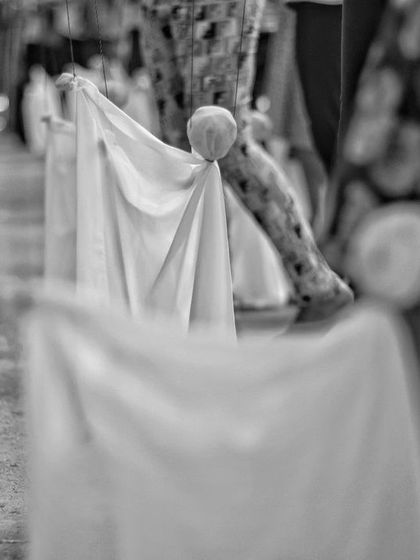 A close-up, artistic shot of the puppets made during a summer camp. The shallow focus emphasizes the texture of the cloth and the simple form of the characters.