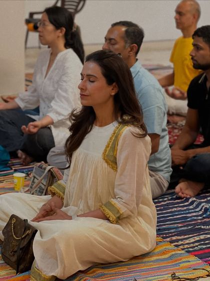 A student sits in serene meditation during a group gathering. Our sessions attract a diverse community of seekers, all united in their quest for inner peace and self understanding.