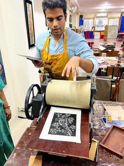 Our instructor, Tarun Sharma, demonstrating how to use the printing press to create a clean, crisp woodcut print of a bird on a branch.