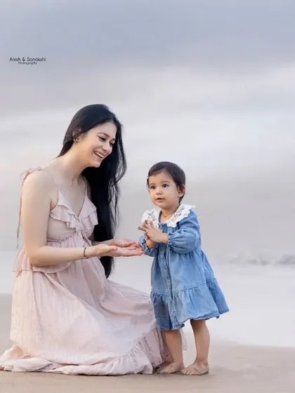 A playful moment of patty-cake on the sand. We encourage natural interactions to capture the most authentic and heartwarming photos.